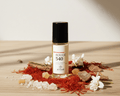 Rouge 540 Unisex Fragrance Oil bottle surrounded by decorative elements like flowers, crystals, and herbs.
